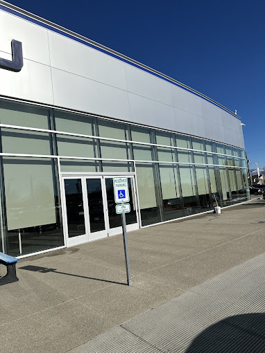 Modern glass and white building exterior with accessible parking sign