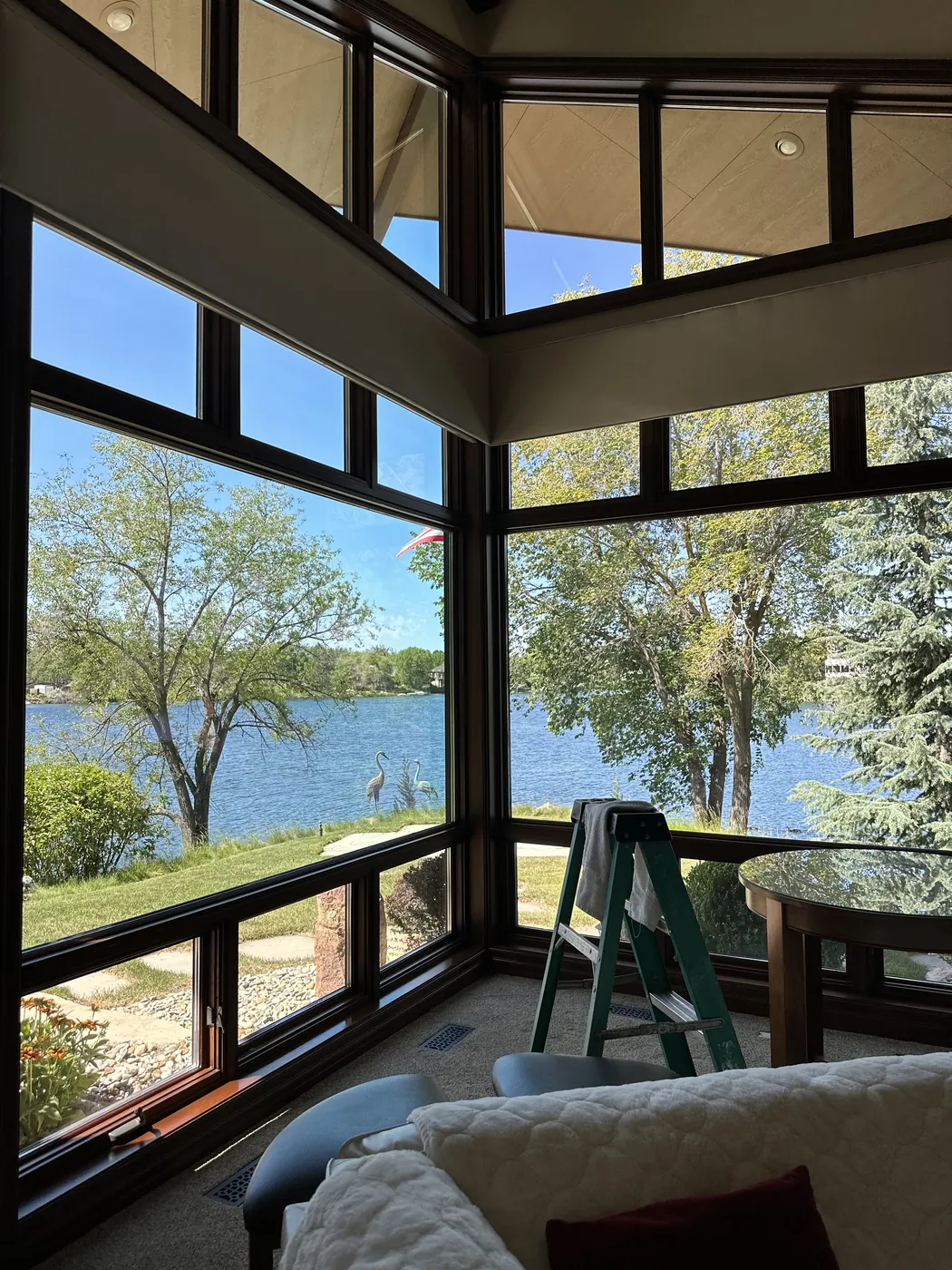 Crystal-clear floor-to-ceiling windows framing a Treasure Valley lake view from a bright living room
