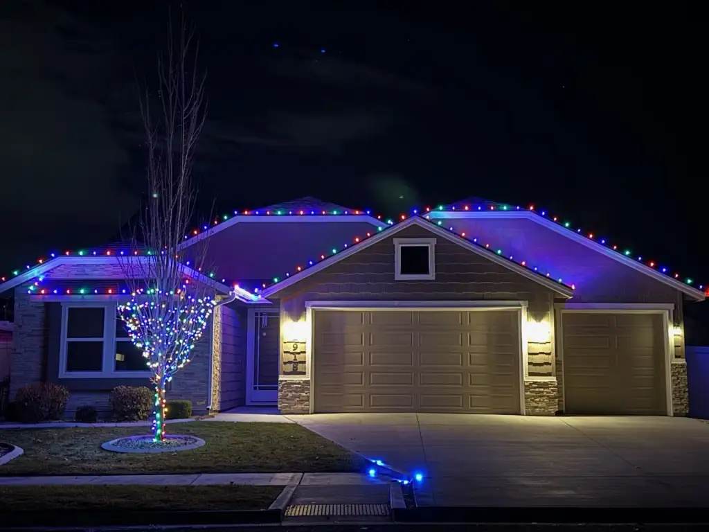 Boise home with custom Christmas lights professionally installed along the roofline at night